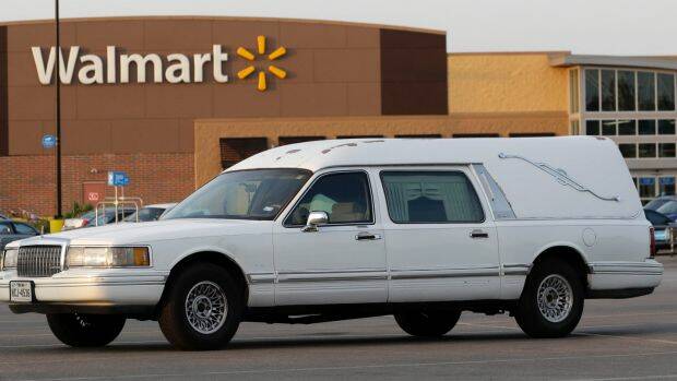 A hearse sits in the parking lot of a Walmart store where eight people were found dead. Photo: ERIC GAY
