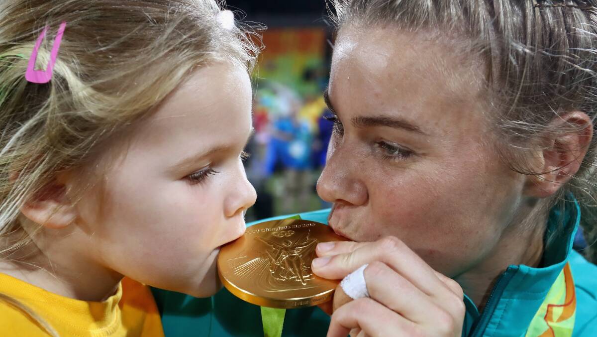 Nicole Beck of Australia kisses her Gold medal with her daughter Sophie after the medal ceremony for the Women's Rugby Sevens on Day 3 of the Rio 2016 Olympic Games at the Deodoro Stadium on August 8, 2016 in Rio de Janeiro, Brazil. Photo: Alexander Hassenstein/Getty Images