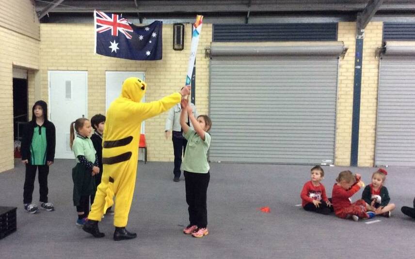 Let the games begin: Pikachu presenting the Olympic Torch to Kaz Digney, representing Japan, at the Allanson Primary School opening ceremony. 
