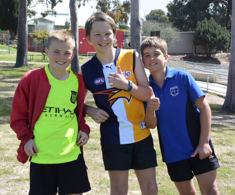 Team pride: George Fuller, Judd Rinder and Marshall Putland showcased their favourite team jerseys during the school's football celebrations. 