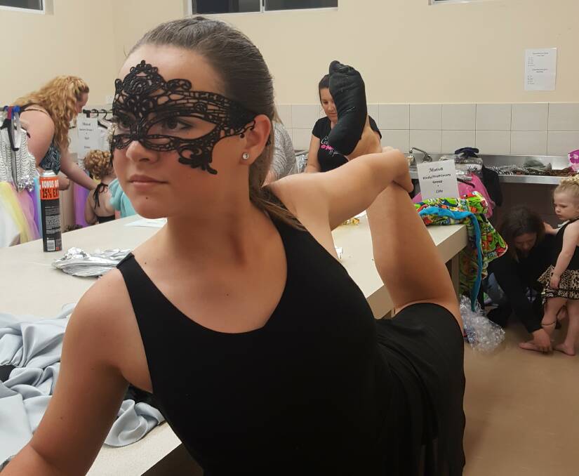 In preparation: Seniors student Kayla Gibbs stretches to get ready for her solo "Dark Horse" at last month's Motiv8 extravaganza. 

