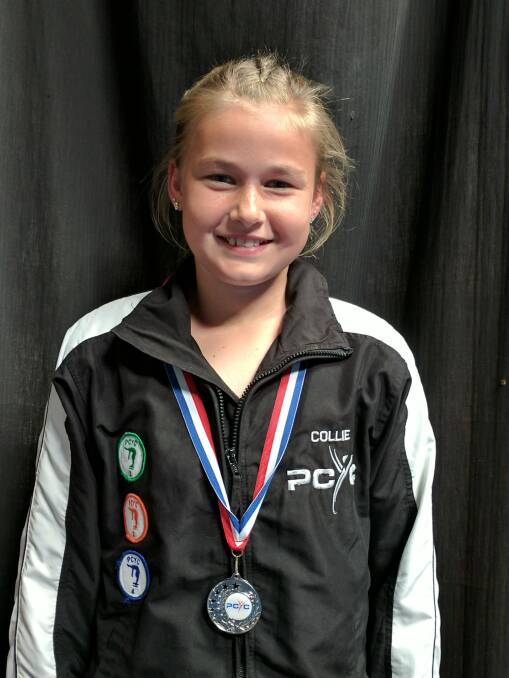 Emily Davenport shows off her medal from the PCYC gymnastics competition.