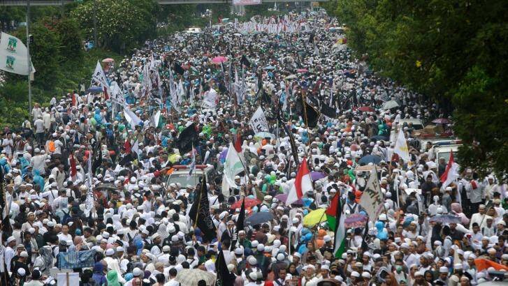 Indonesian Muslims march during a rally against Jakarta's minority Christian Governor on Friday.  Photo: Tatan Syuflana