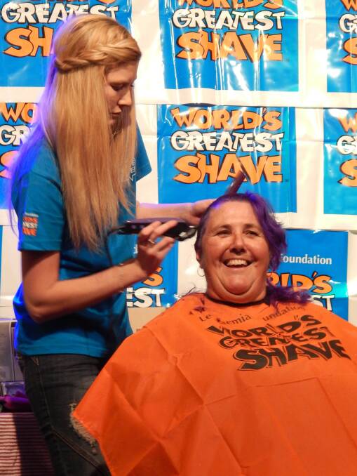 Halfway there: Shenae Magill gets to work shaving off Helen Winfield's purple hair.
