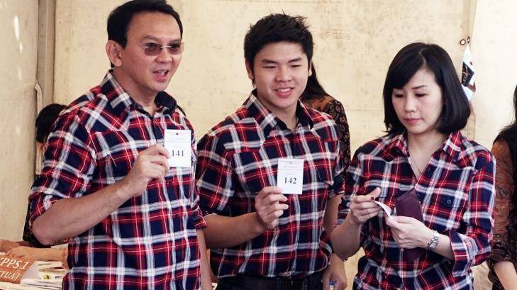Jakarta Governor Basuki Tjahaja Purnama, left, casts his ballot with his son Nicholas and wife Veronica Tan, all in his campaign's trademark plaid shirt. Photo: Jefri Tarigan