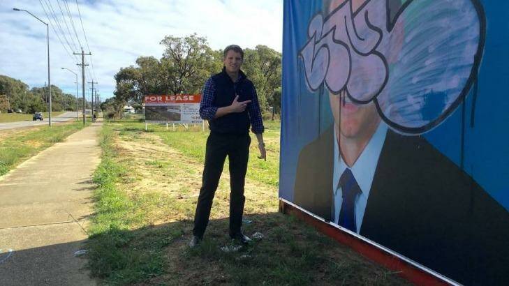 Canning MP Andrew Hastie with the campaign poster that copped a spray from a vandal.  Photo: Facebook