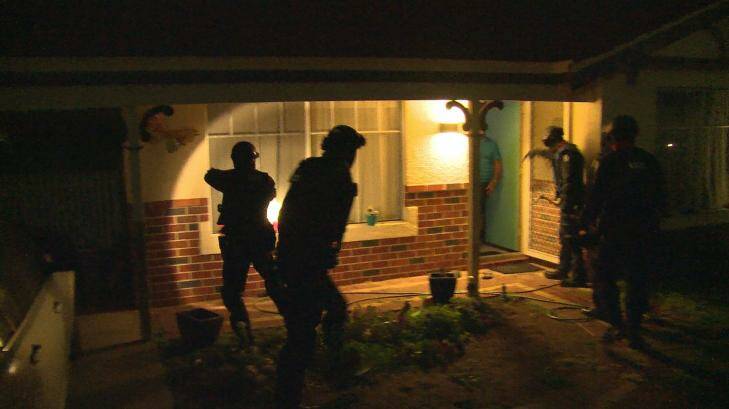 Police at the door of one of the properties raided on Thursday morning.