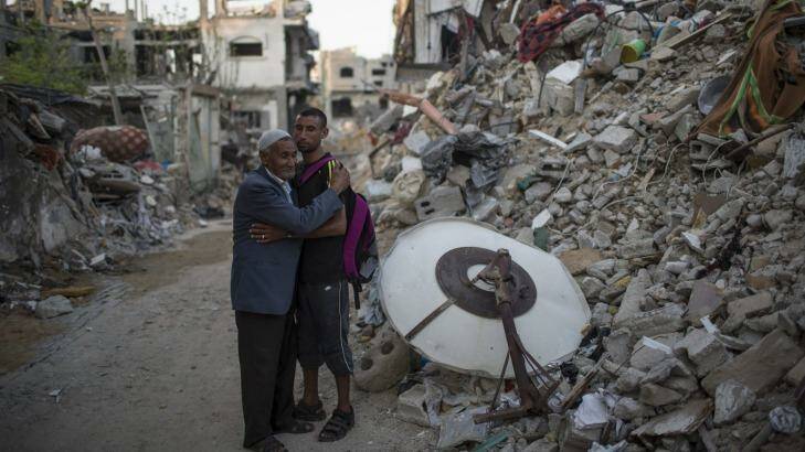 Palestinian Olympian Nader al-Masri and his father beside the rubble of their home in Beit Hanoun in Auust 2014. Photo: New York Times