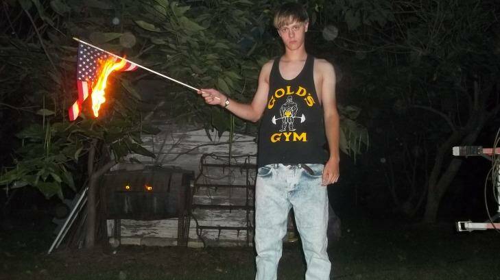 This undated photo appears to show Dylann Roof burning the US flag.  Photo: Handout