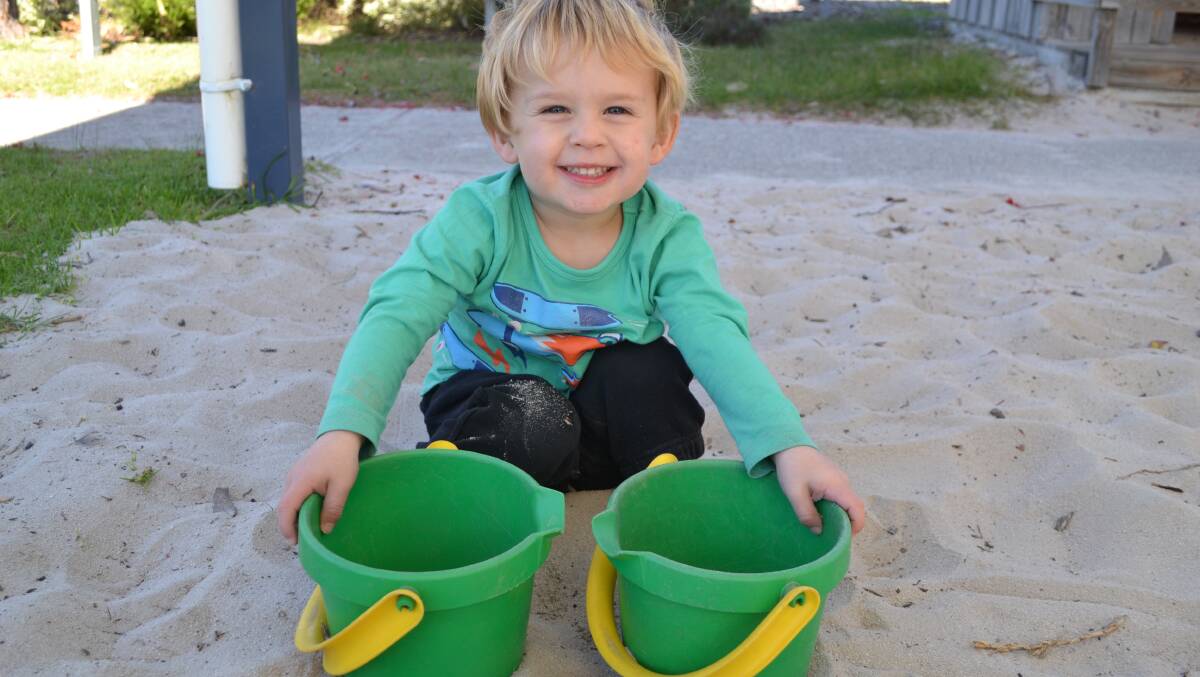 Bucket smile: Taj Flatt builds sand castles in the out door play area.