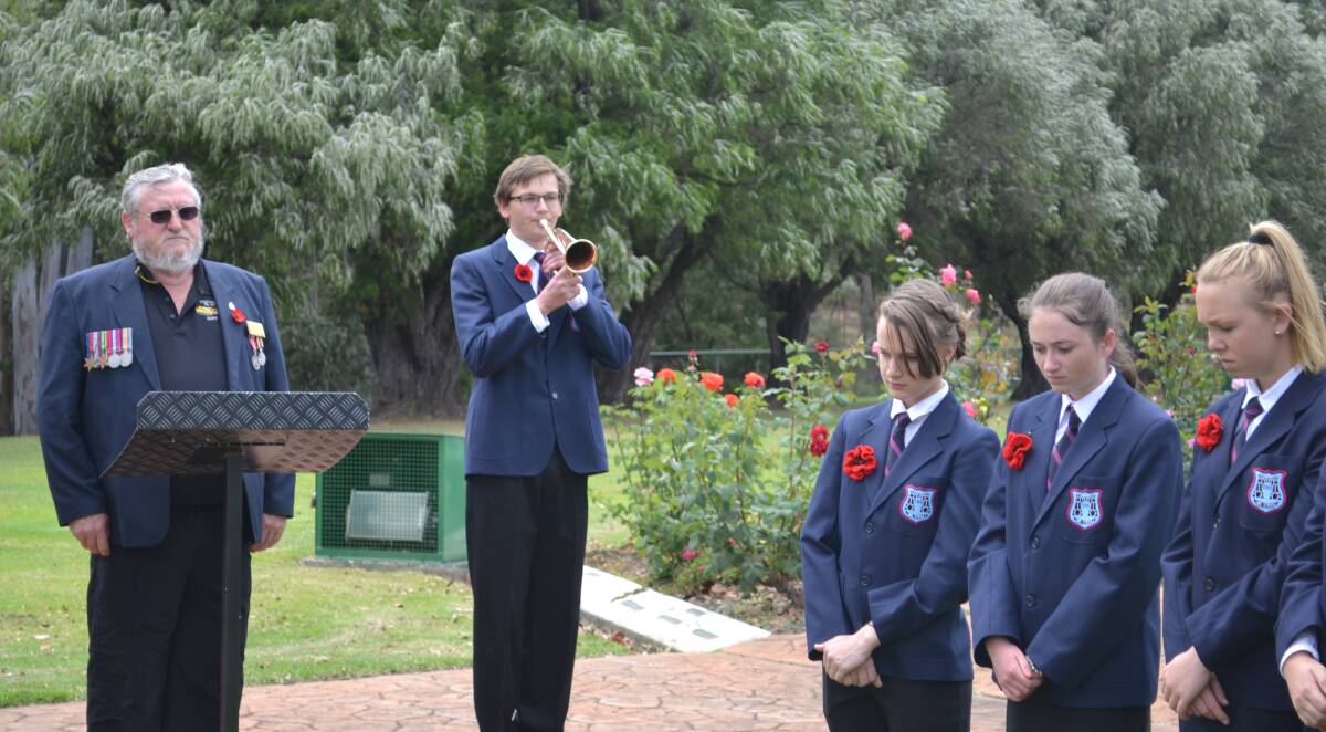 James Moulden plays the last post, flanked by RSL president Gary Benton and fellow Collie Senior High School students. 