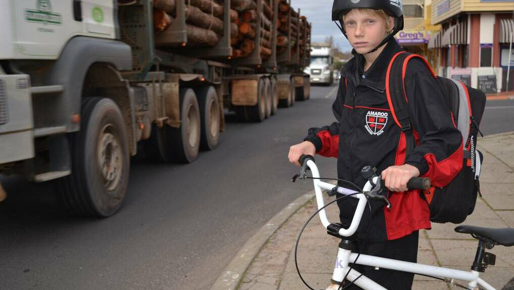 Danger: Teenager Logan Madsen attempts to cross Throssell Street as trucks drive past earlier this year.