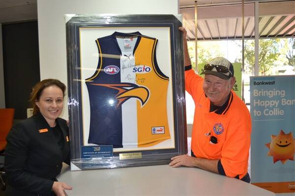 AUCTIONED: Bank West manager Narelle Michalak and Peter Martin hold the framed West Coast Eagles jumper auctioned at the Zac Hart charity auction. 