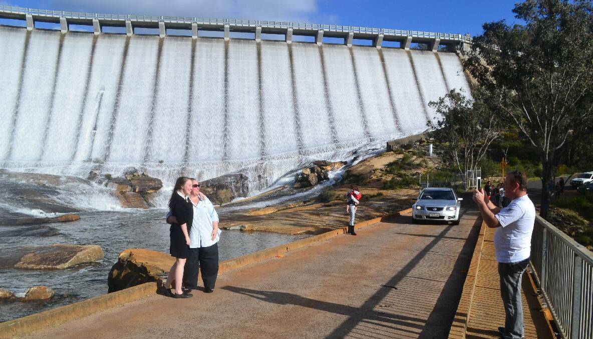 Waterworks: Wellington Dam begins to overflow for the first time since 2009, with parents and children flocking to see the amazing sight. Photos by Mackenzie Dixon.