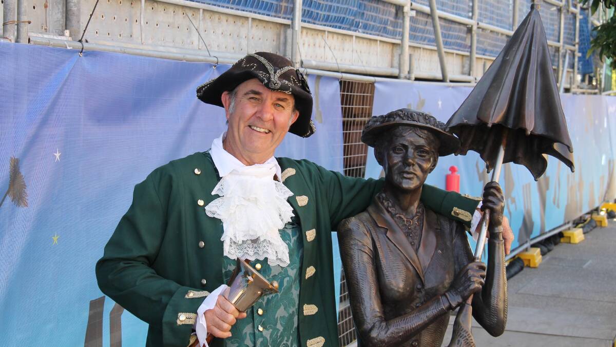 A celebration of all things Mary Poppins … Maryborough Town Crier Ken Ashford with a statue of one of the town’s most famous daughters.