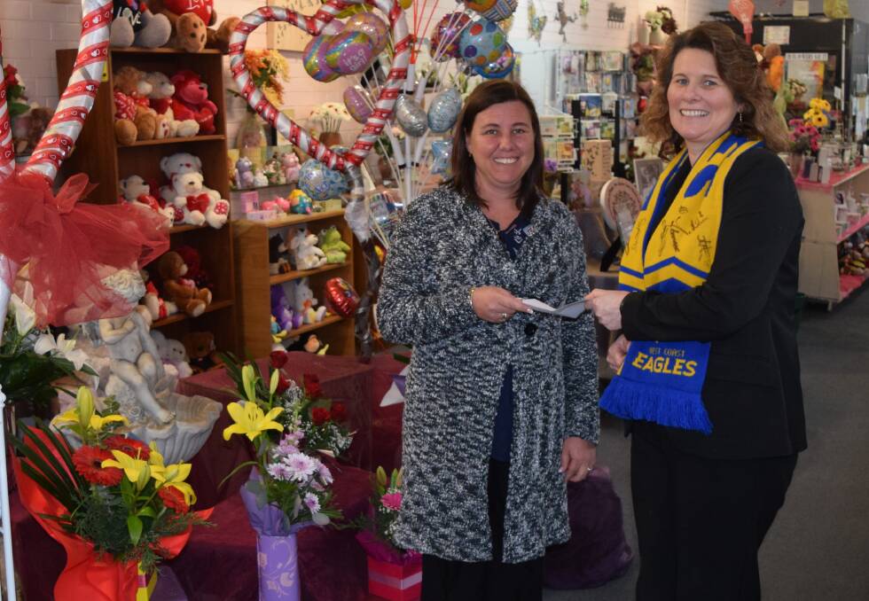 The Collie Mail's Angela Fleay hands over the grand final tickets to footy tipping competition winner Corene King.
