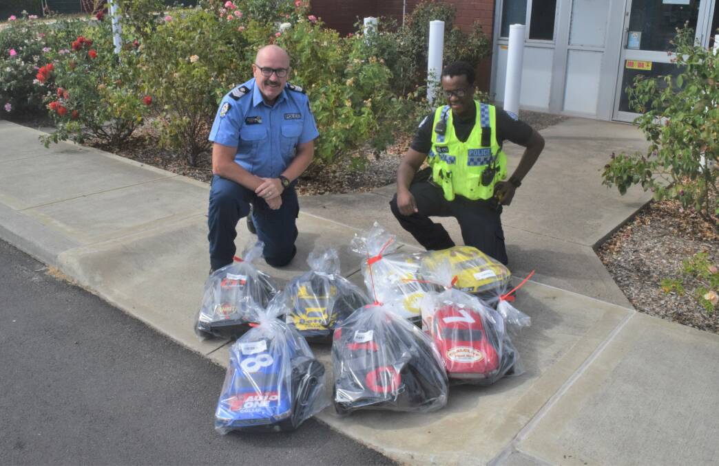 Senior Sergeant Soutar and Constable Ngari with the seven recovered radio-controlled cars. Photo: Ashley Bolt