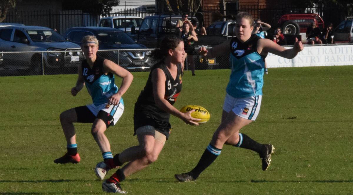 Meg Purton and Tahlia Dawson-Gibbs attempt to stop Harvey's Fleur Parker in the Eagles' 73 point loss. Photo: Ashley Bolt