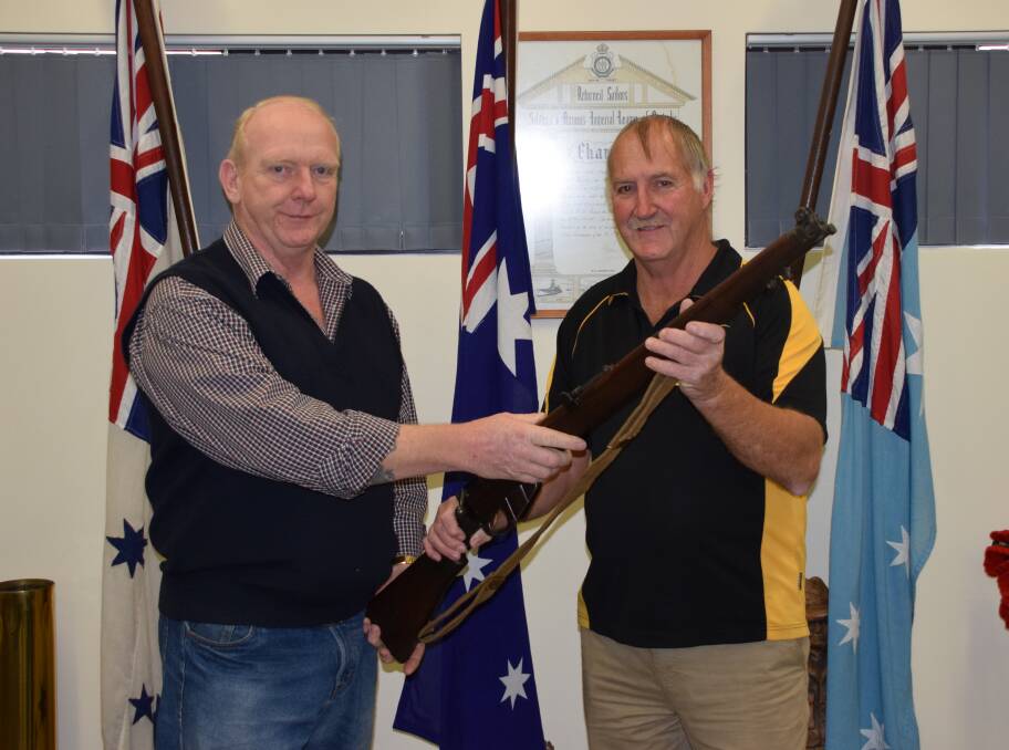 Military historian Tony Kent returning the restored rifle to Alan Bowers, who originally donated it to the RSL. Photo: Ashley Bolt