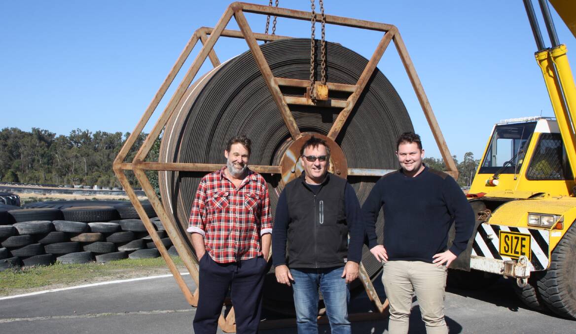 Collie Motorplex caretaker David Gapes, Motoring South West chairman Terry Massara and Cody Irvine with one of the five reels of conveyor belt donated by South32 Worsley Alumina. Photo: supplied