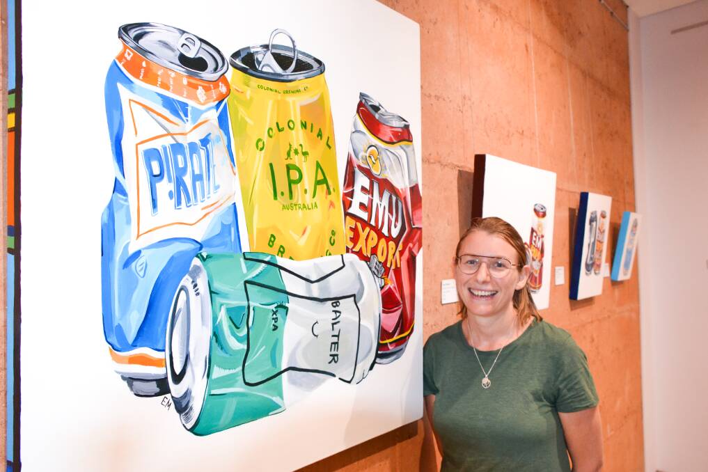 Local artist Elisha McGurkin with her bright and bold beer can paintings at the Collie Art Gallery. Photo: Breeanna Tirant 