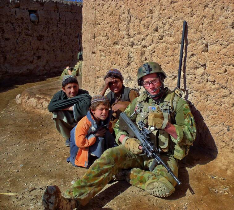 AFGANISTAN: Dean Williamson with a few local Afghan children. Photo: supplied.