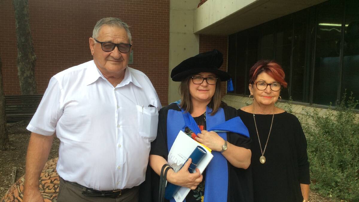 Joanne Piavanini with her proud parents John and Merrilyn at her graduation in December.