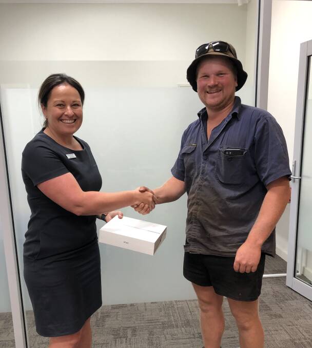 Classy: Narelle Michalak presents Todd Lubcke with the iPad won by his dad, Craig Lubcke, who proved the best wool classer on the day of Sheepfest at the Rural Bank stand. Photo: supplied. 