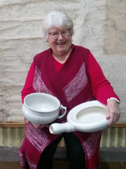 Pan handling: Museum volunteer Robin with a selection of bed pans, which are on display at Coalfields Museum. Photo: Nola Green.